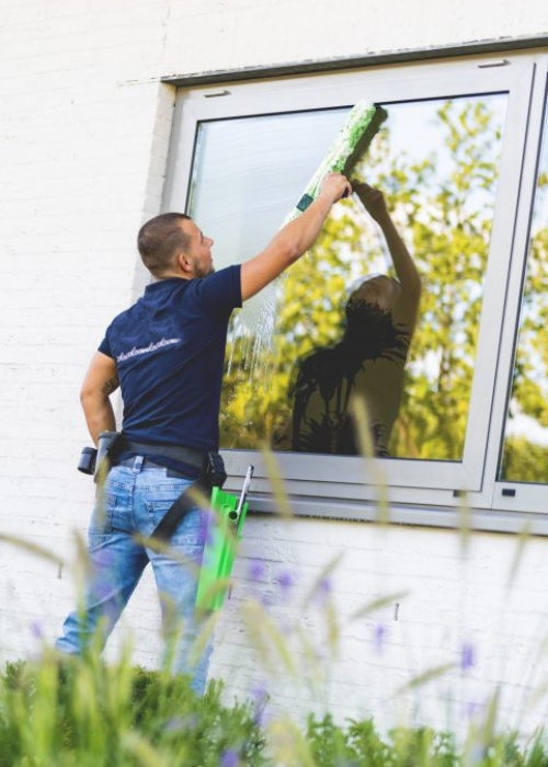 ECS-medewerker aan het werk met een wissen op glas